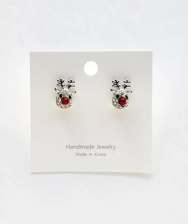 Pair of silver rhinestone reindeer-shaped earrings with red noses on a white card with 'Handmade Jewelry Made in Korea' text.